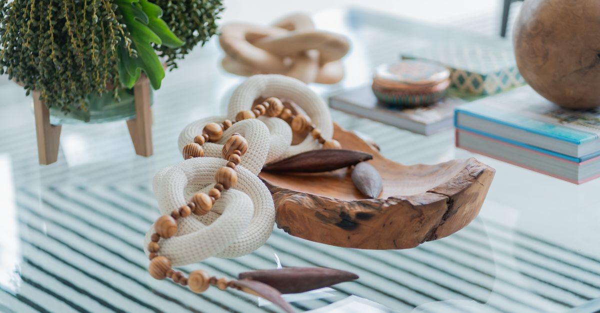 Stylish handmade decor with wooden and rope elements on a glass table, adding charm to modern interiors.